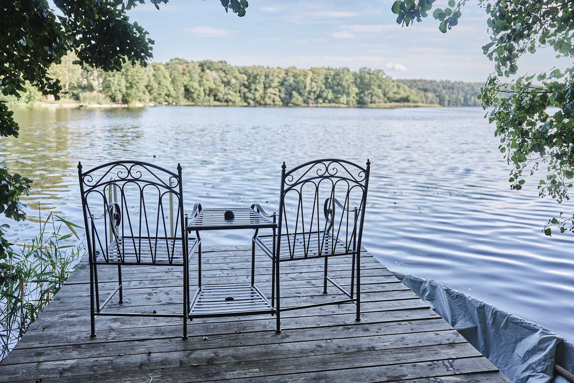 Zwei Stühle mit Tisch vor dem See